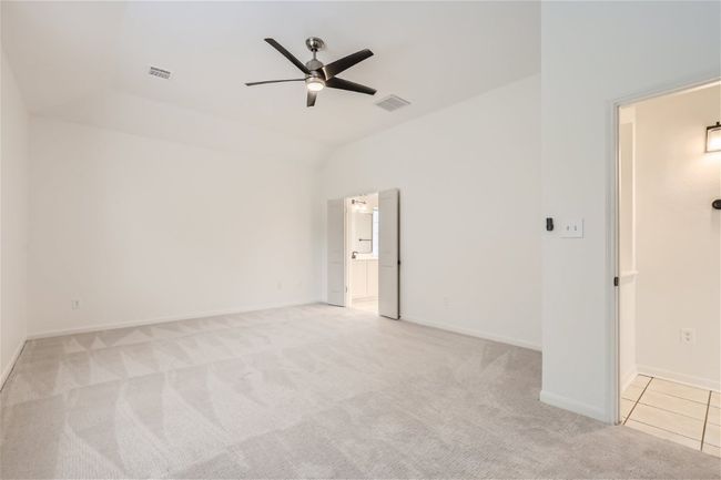 Spare room featuring a ceiling fan, lofted ceiling, light carpet, and baseboards | Image 18