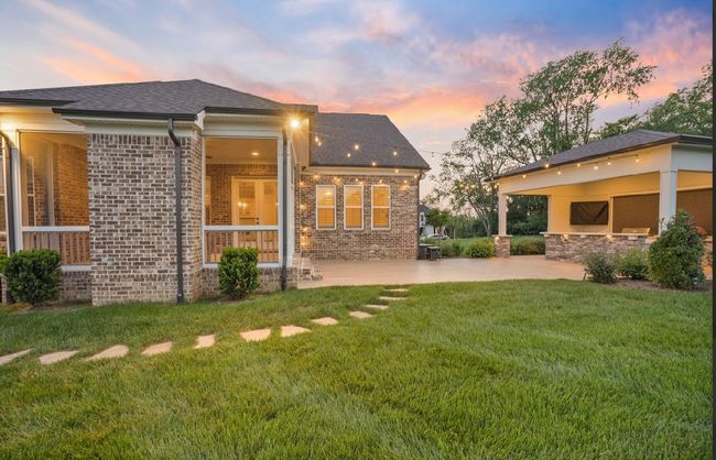 Twinkle lights, a screened in patio with fireplace, and plenty of space to gather—this backyard is ready for cozy nights and summer cookouts! | Image 4