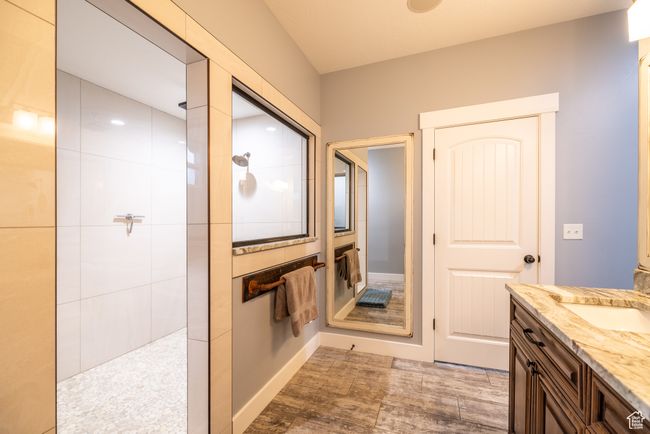 Bathroom featuring walk in shower, vanity, and wood finished floors | Image 33
