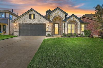 View of front facade with a yard and a garage | Image 1