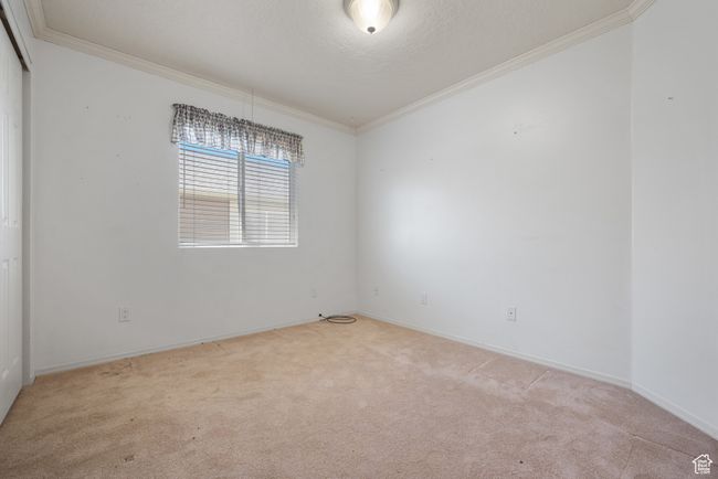 Carpeted spare room with crown molding and baseboards | Image 16