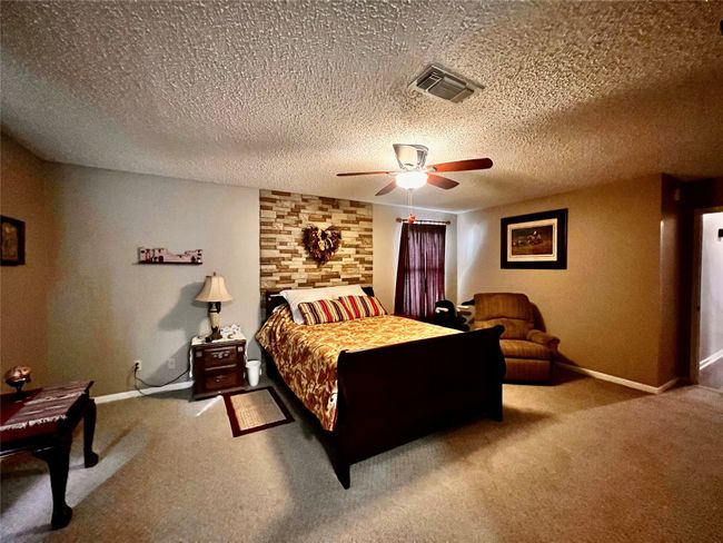 Carpeted bedroom featuring ceiling fan and a textured ceiling | Image 10