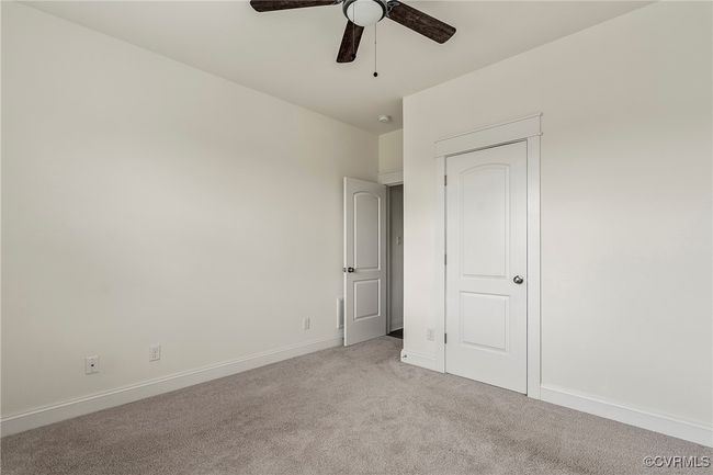 Unfurnished bedroom with light colored carpet and ceiling fan | Image 20