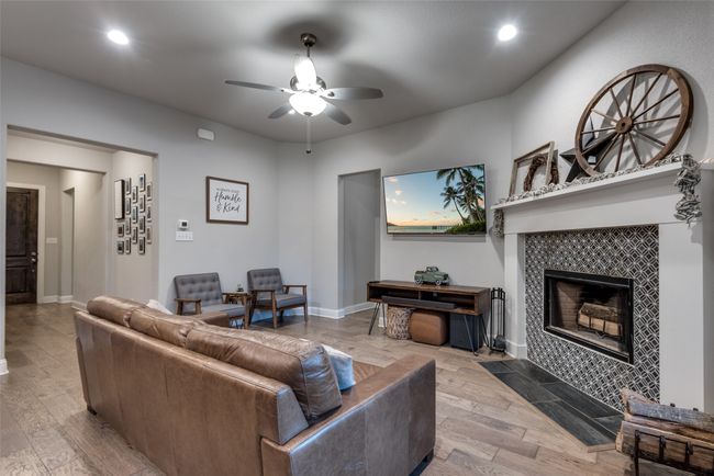 Living area featuring a ceiling fan, wood finished floors, a fireplace, baseboards, and recessed lighting | Image 13
