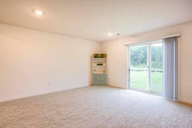 Generous flex space perfect for a game area, hobby room, or additional seating, with backyard access. | Image 35