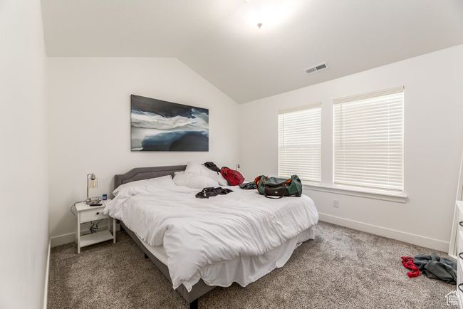 Carpeted bedroom featuring visible vents, baseboards, and vaulted ceiling | Image 12