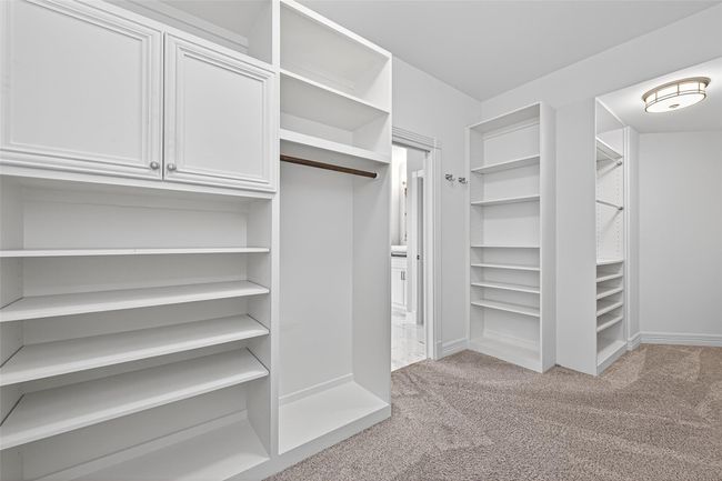 Your carefully throughout and designed walk-in closet with custom built-ins featuring plenty of shelves and variety to satisfy any want or need you ever desired when it comes to organization. | Image 26