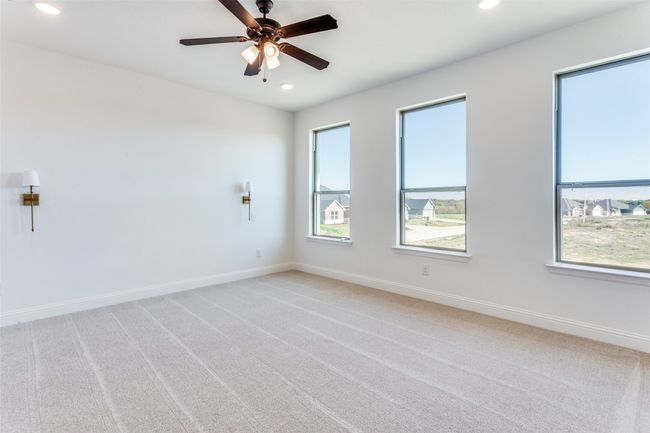 Carpeted empty room featuring plenty of natural light and ceiling fan | Image 12