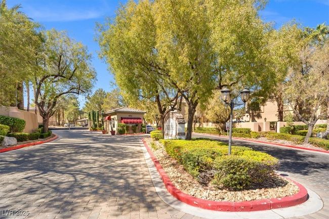 View of road featuring curbs, street lighting, and a gated entry | Image 23