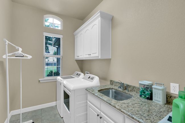Laundry room with separate washer and dryer, sink and cabinet space | Image 31