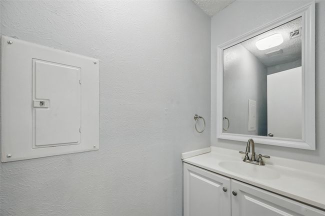 Bathroom featuring electric panel, a textured ceiling, and vanity | Image 16