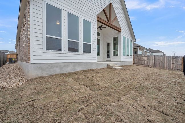 Rear view of property with cooling unit, fence, and ceiling fan | Image 26