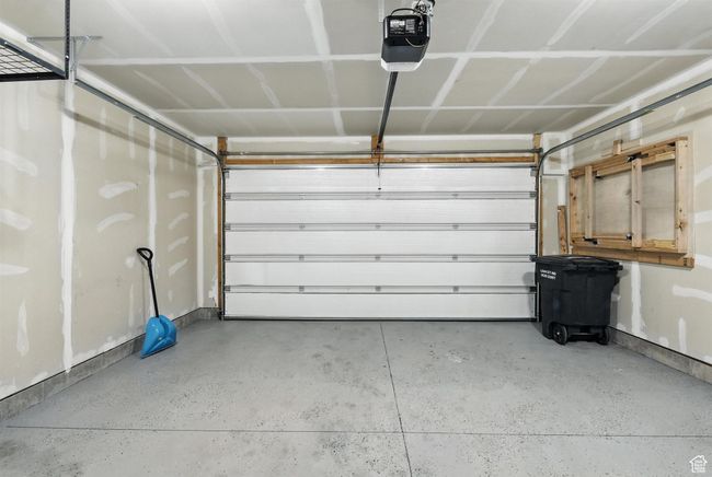 Garage featuring a garage door opener and baseboards | Image 22