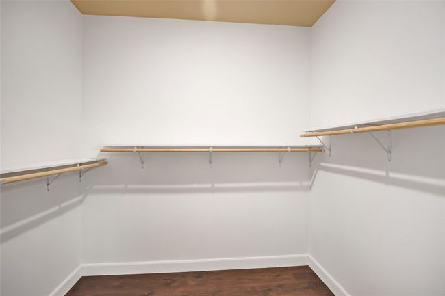 Spacious closet with dark wood finished floors | Image 24