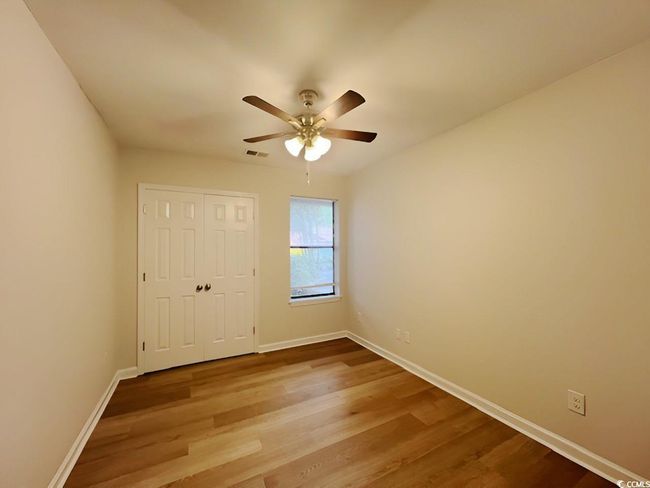 Empty room featuring ceiling fan, baseboards, and wood finished floors | Image 15