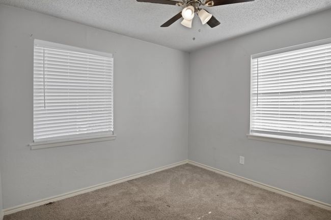 Carpeted spare room with baseboards, a textured ceiling, and a ceiling fan | Image 20