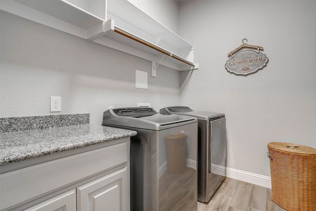 Laundry room with washer and clothes dryer and light wood-style floors | Image 39