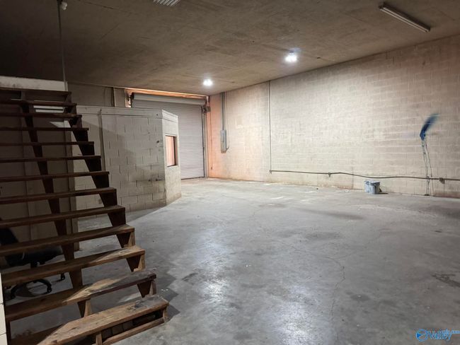 concrete floors, rollup door, walk-in door, steps to storage | Image 7