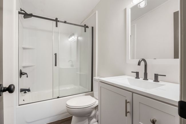 The hall bathroom is conveniently located between the two secondary bedrooms, making it easily accessible for guests and family alike. With brand-new fixtures and lighting, this refreshed space feels modern, bright, and ready to enjoy! | Image 10