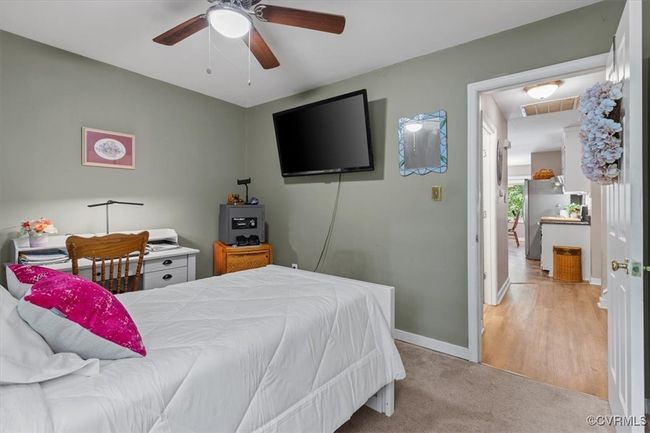 Bedroom featuring baseboards, ceiling fan, freestanding refrigerator, and carpet floors | Image 25