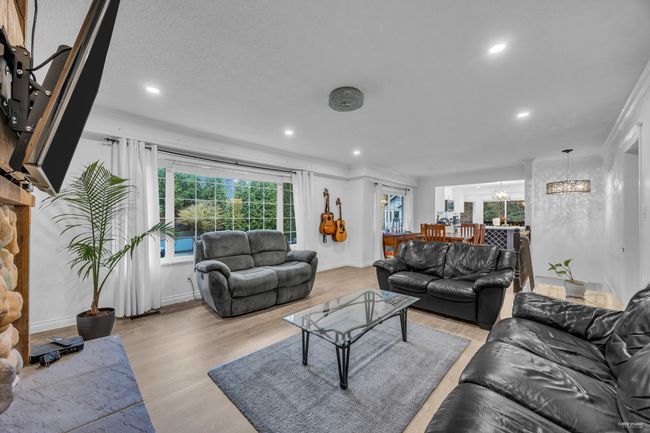 Living room featuring ornamental molding, light wood-type flooring, recessed lighting, and a chandelier | Image 7