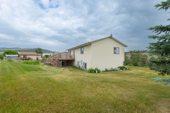 Back of house featuring a deck with mountain view, a yard, and stairs | Image 30