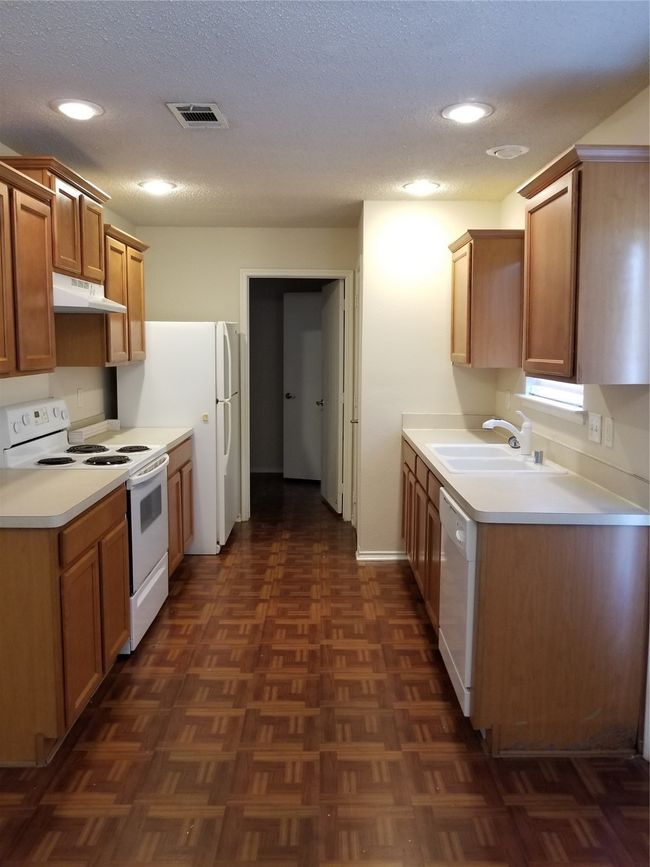 Kitchen with stove, range hood, dishwashing machine, recessed lighting, and light countertops | Image 11