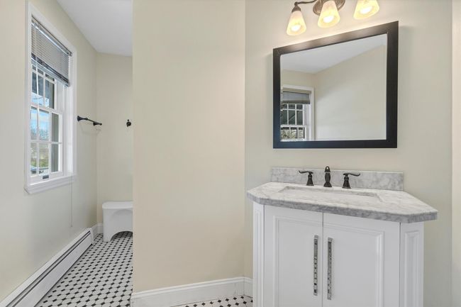 Bathroom featuring a baseboard radiator, baseboards, vanity, and tile patterned floors | Image 29