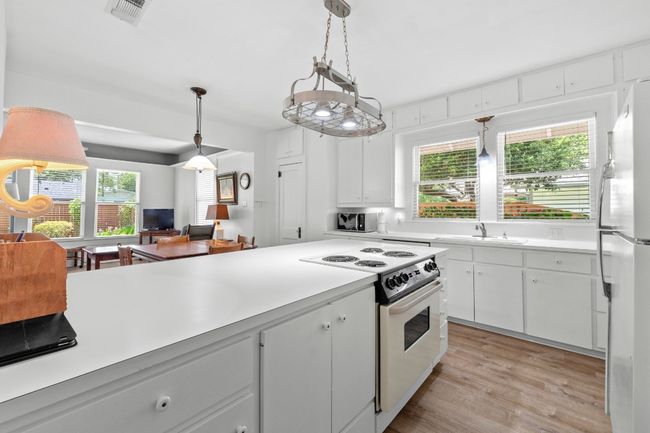 Kitchen featuring white appliances, light countertops, and white cabinets | Image 13