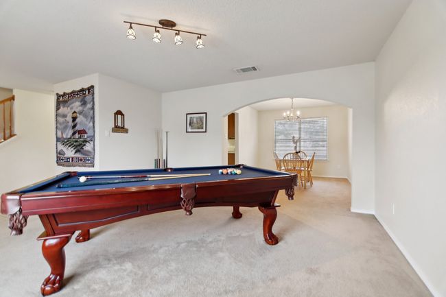 Rec room with arched walkways, pool table, visible vents, and a chandelier | Image 14