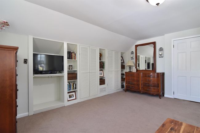 Carpeted bedroom featuring lofted ceiling | Image 13