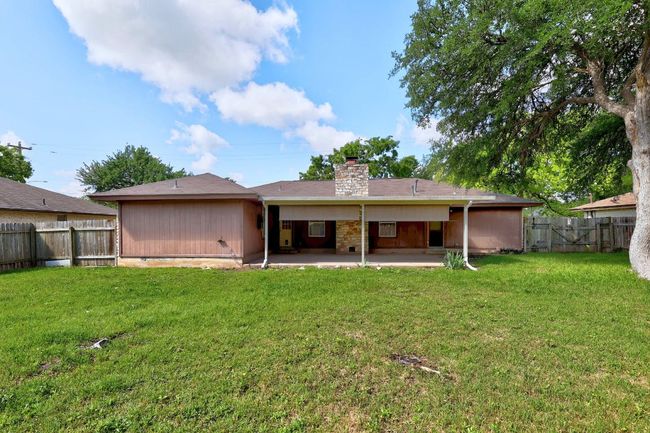 Rear view of house with a chimney and a patio area | Image 25