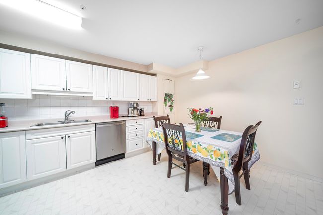 Kitchen featuring stainless steel dishwasher, a sink, light countertops, and white cabinets | Image 22