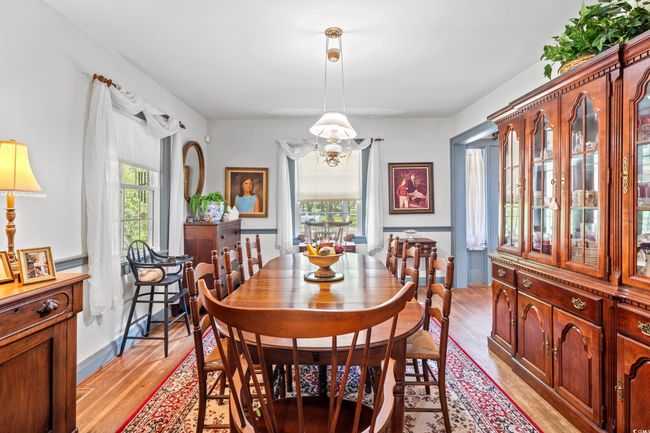 Dining space with light wood-style floors and a chandelier | Image 11