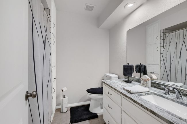 Full bath with vanity, light tile patterned flooring, a textured wall, and a shower with shower curtain | Image 21