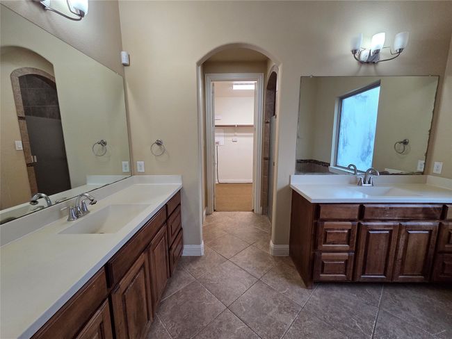 Full bath with vanity, tile patterned flooring, and a walk in closet | Image 22