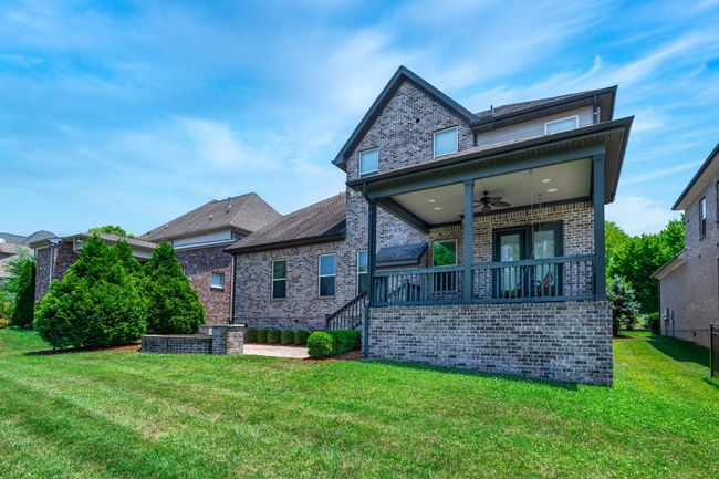 The back yard features a covered porch, patio, and, gas grill. This is the perfect outdoor entertaining area. | Image 54