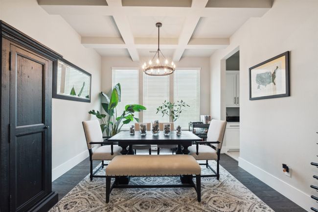 Dining room with coffered ceiling, a chandelier, beamed ceiling, and dark wood finished floors | Image 7