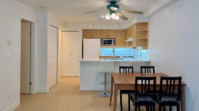 Kitchen featuring stainless steel microwave, freestanding refrigerator, a ceiling fan, stove, and open shelves | Image 7