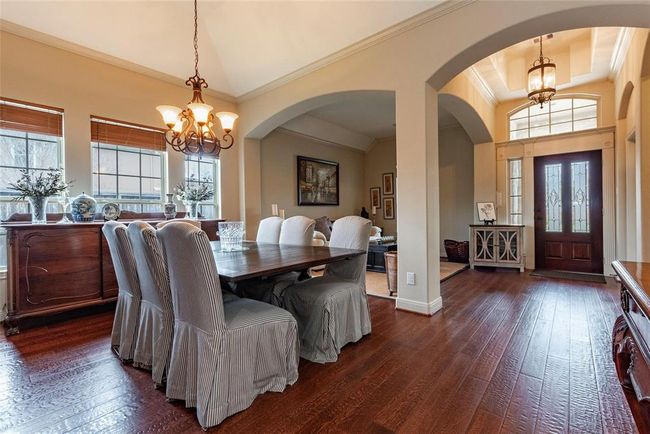 Spacious formal dining room with wood floors and high ceilings. | Image 16