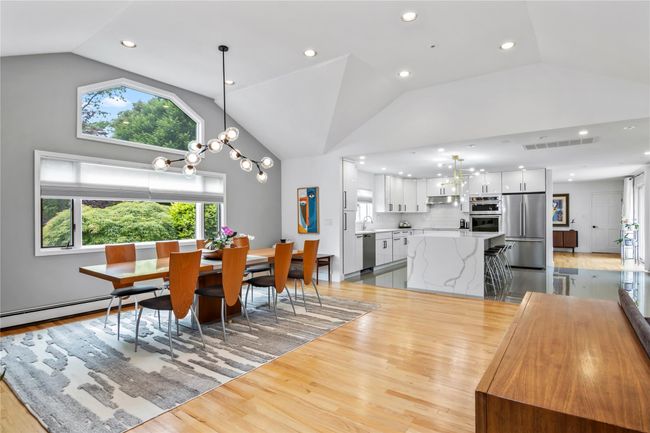 Dining space featuring light wood-type flooring, a chandelier, recessed lighting, and high vaulted ceiling | Image 13