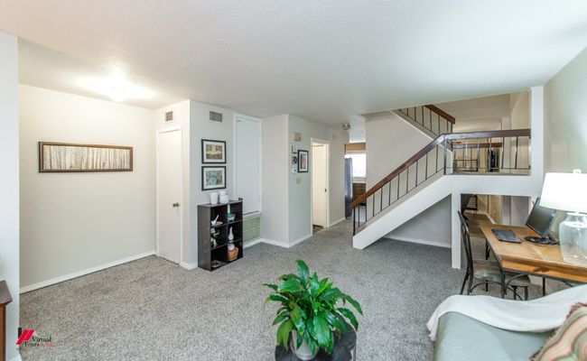 Carpeted living area with baseboards, stairs, and visible vents | Image 6