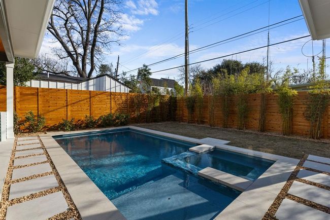 View of pool featuring a pool with connected hot tub and a fenced backyard | Image 35
