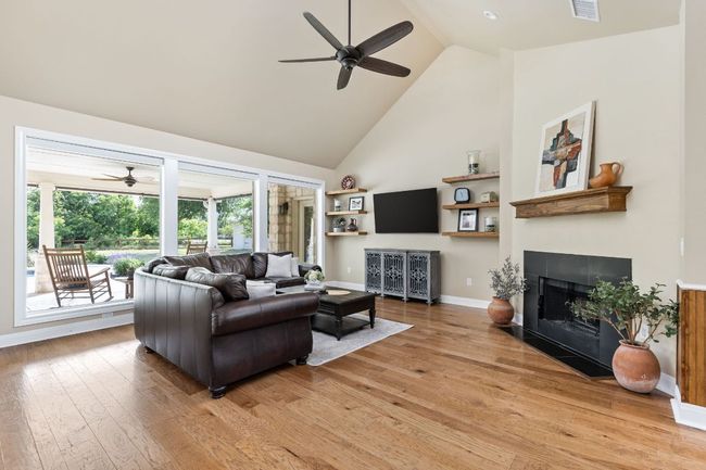 A vaulted ceiling and warm-toned hardwood flooring adds charm and character to the space. | Image 7