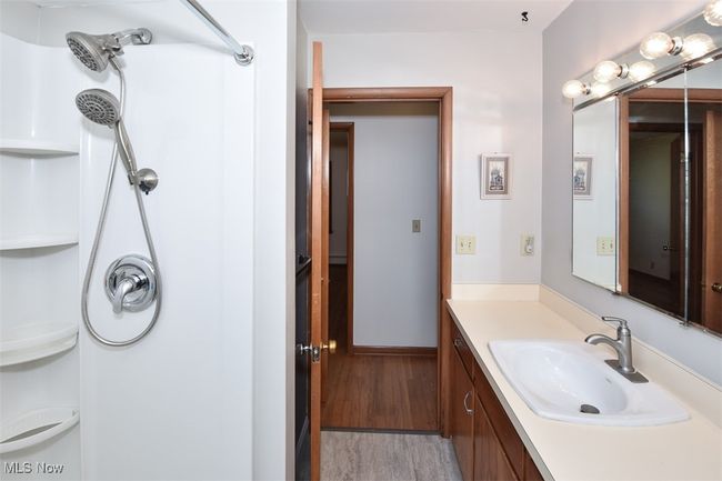 Full bathroom with wood finished floors, vanity, and a shower | Image 38
