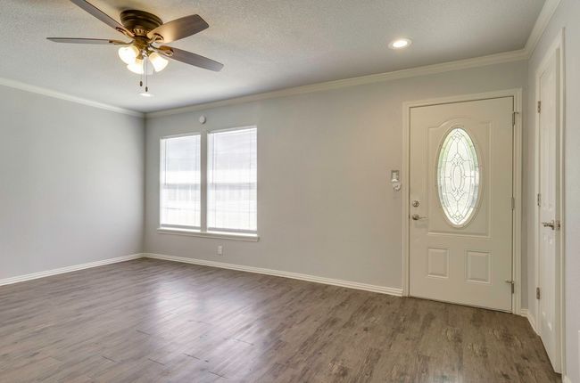 Entrance foyer with dark wood-style flooring, ceiling fan, ornamental molding, recessed lighting, and a textured ceiling | Image 7