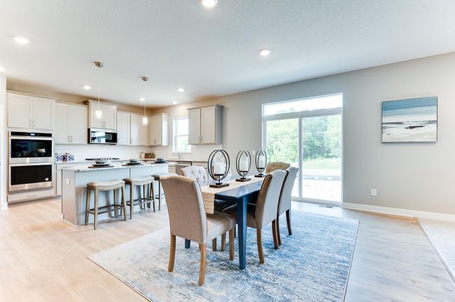Centered within the main level, the home's dining space spans nearly 17-feet wide and rests just adjacent to the easy access onto your future deck! Photo of model home, color and options will vary. | Image 13