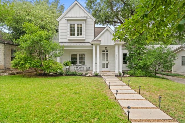 View of front of property featuring board and batten siding, a standing seam roof, a porch, and a front yard | Image 39