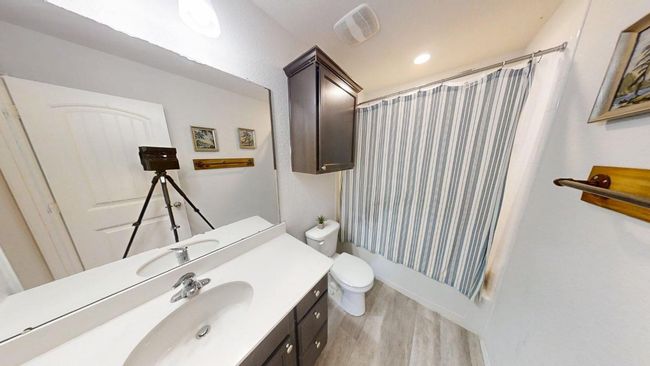 Bathroom featuring vanity, wood finished floors, shower / tub combo with curtain, toilet, and recessed lighting | Image 6