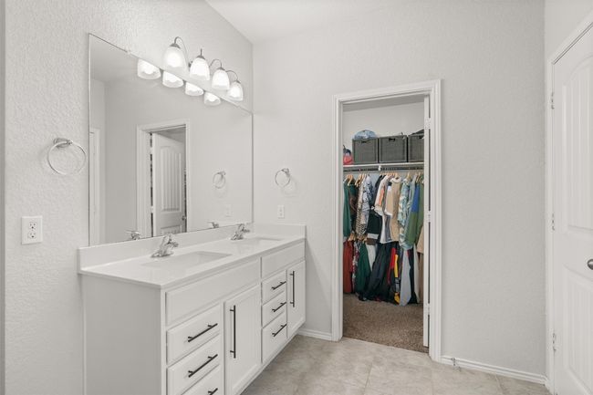 Bathroom with double vanity, tile floors, and a spacious walk-in closet | Image 16